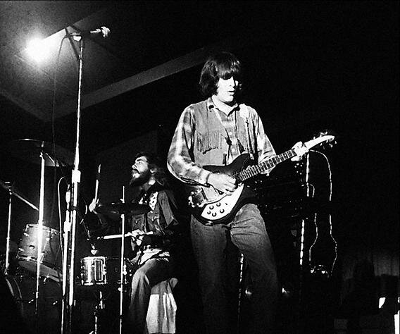 Young John Fogerty playing his Rickenbacker guitar on stage with Creedence Clearwater Revival, black-and-white live shot